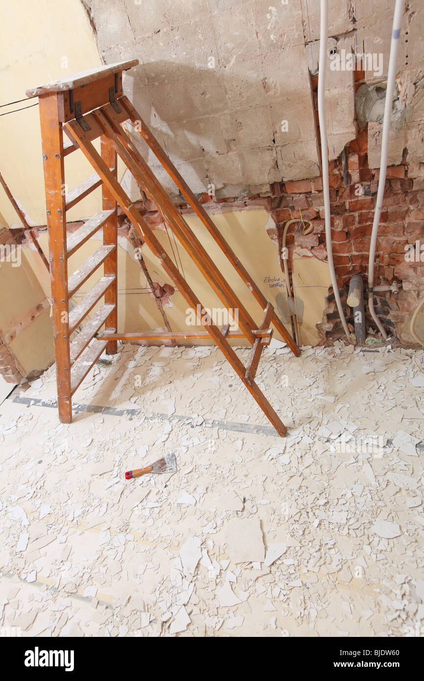 Working In Kitchen And Removing Old Paint Of Ceiling With Ladder