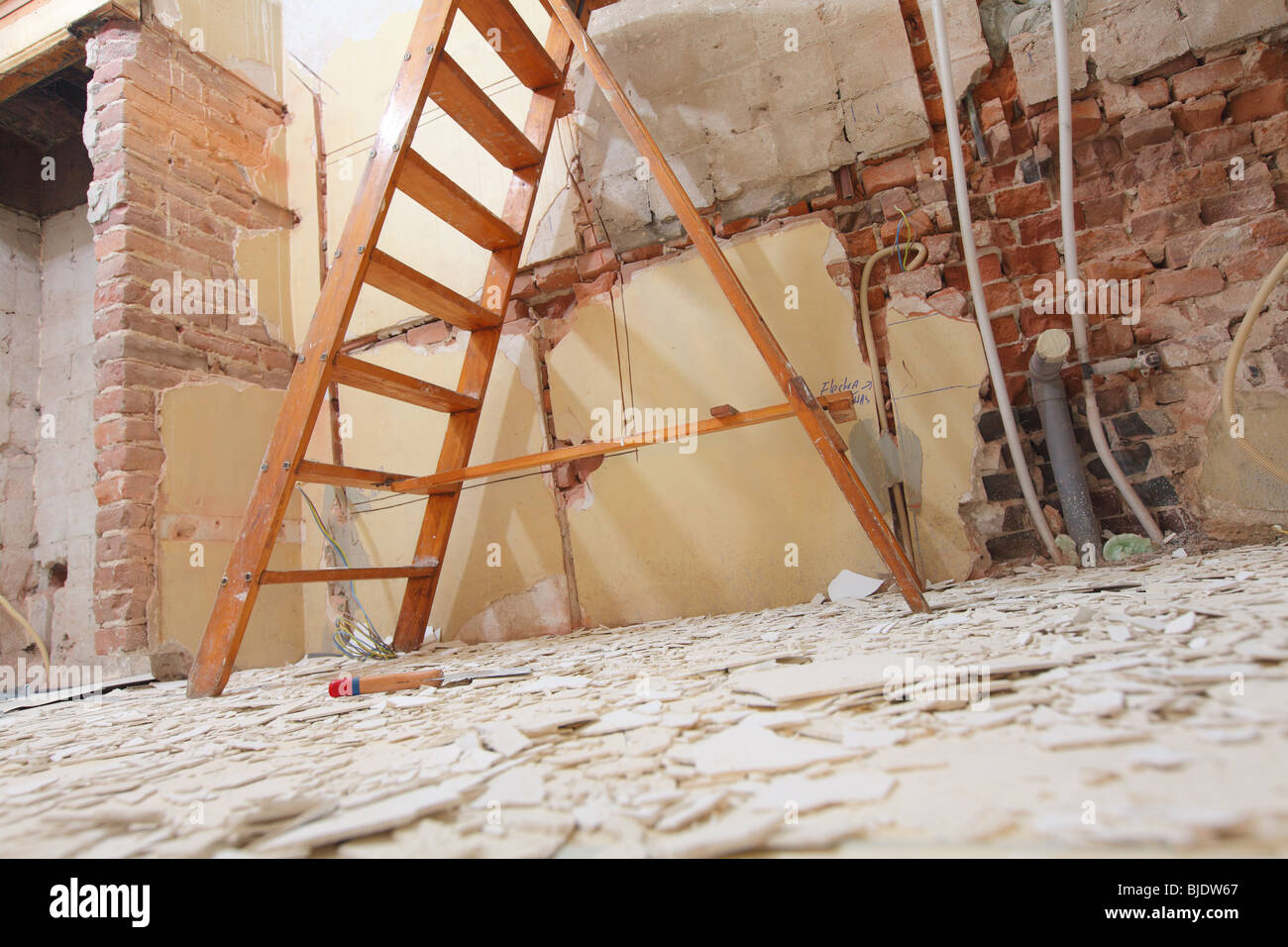 Working In Kitchen And Removing Old Paint Of Ceiling With Ladder