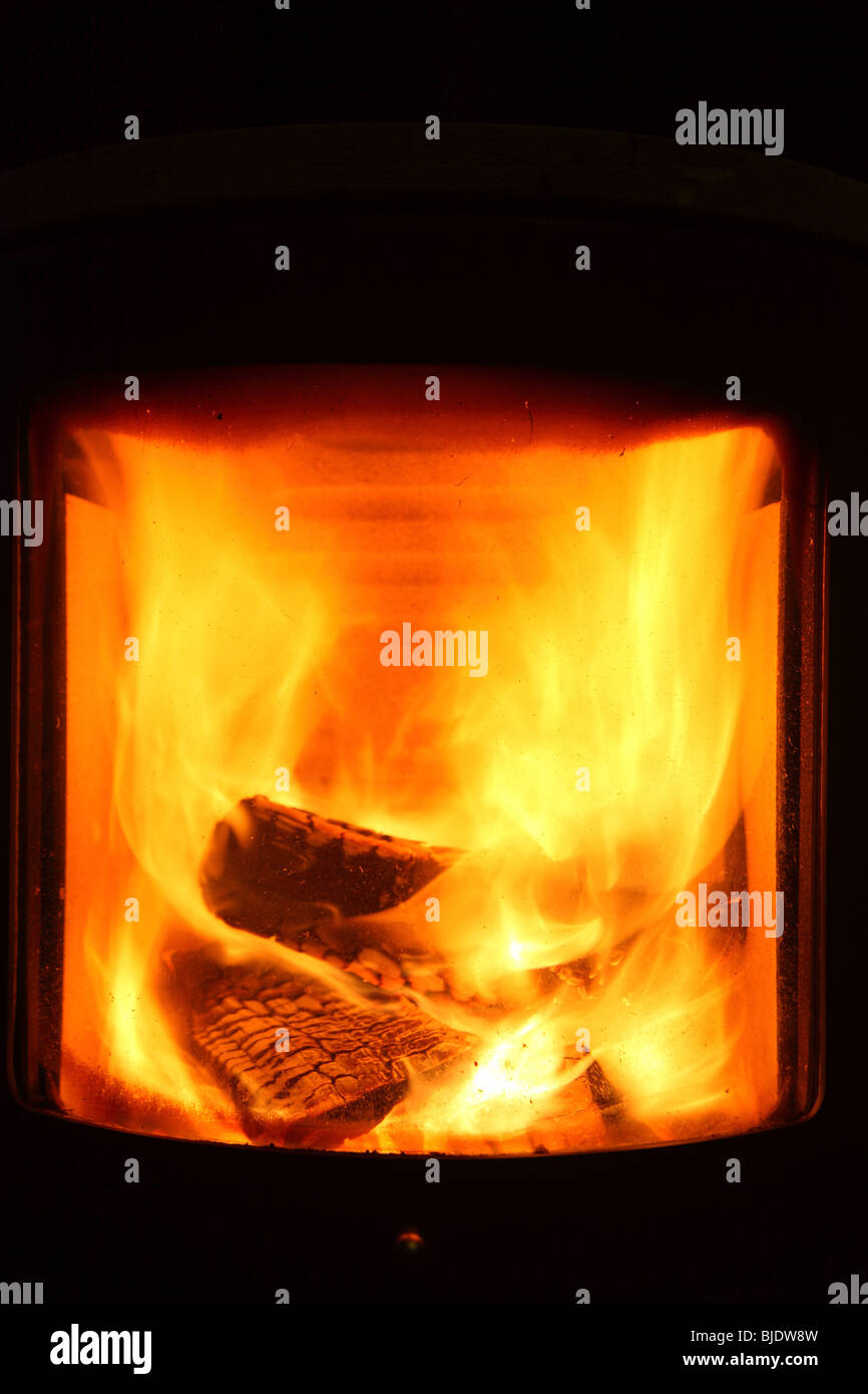 fire place burning wood log stove inside house in winter Stock Photo