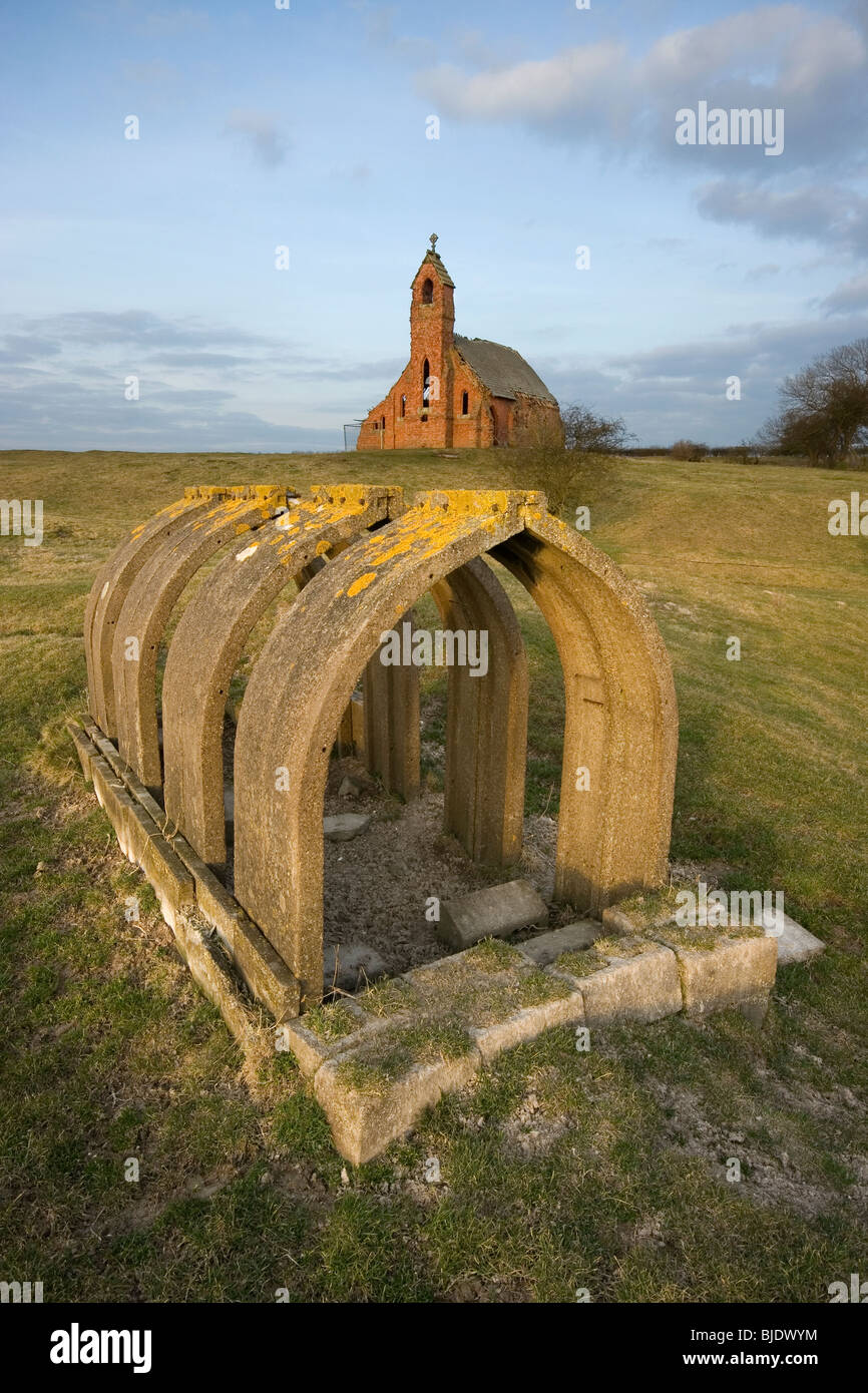 The remains of a WWII air raid shelter and the ruined Holy Trinity church (built 1890) in Cottam, East Riding of Yorkshire, UK Stock Photo