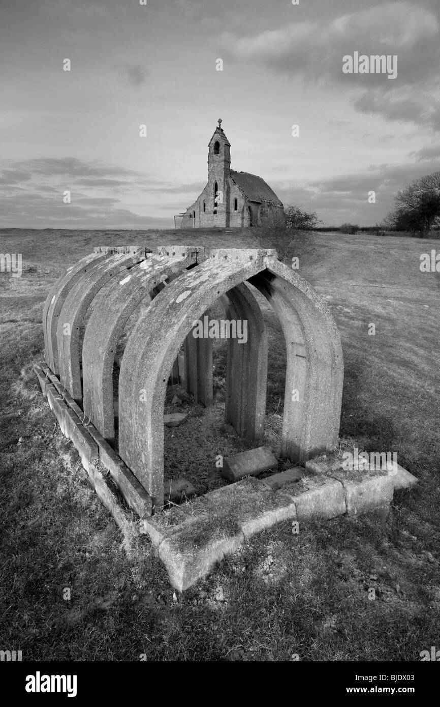 The remains of a WWII air raid shelter and the ruined Holy Trinity church (built 1890) in Cottam, East Riding of Yorkshire, UK Stock Photo
