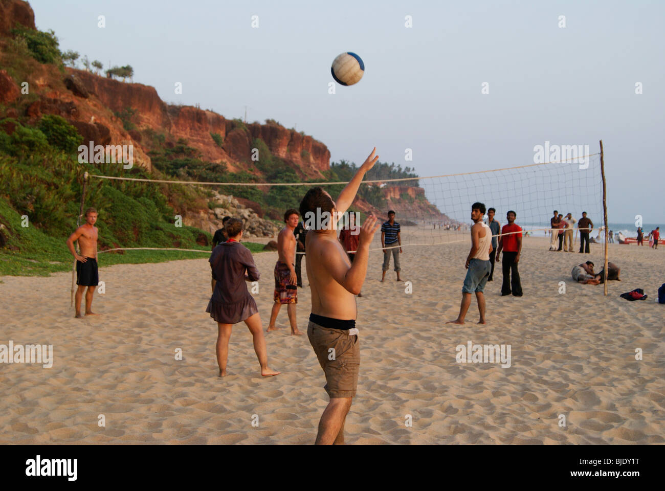 Playing Beach volleyball in Varkala Tourist beach Between native Indians and foreigners from Different countries Stock Photo