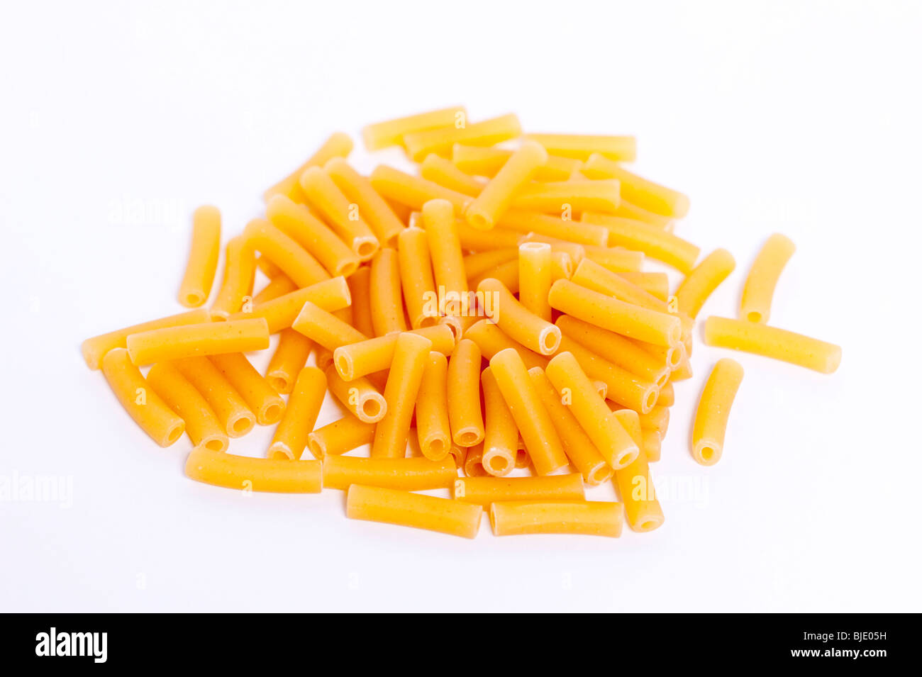 A pile of uncooked macaroni pasta tubes on a white background Stock Photo