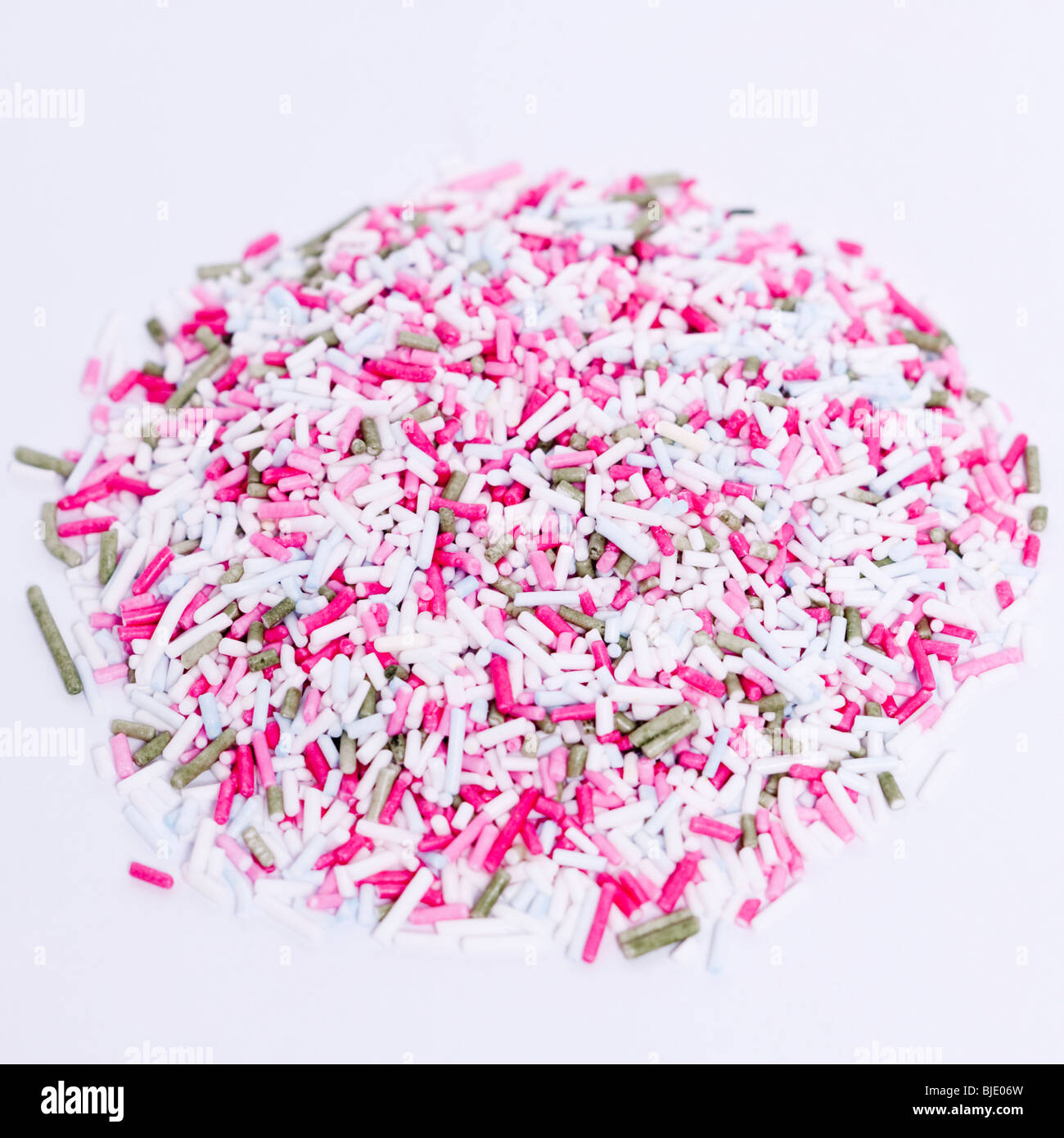 A pile of coloured sugar strands for cake decorating on a white background Stock Photo