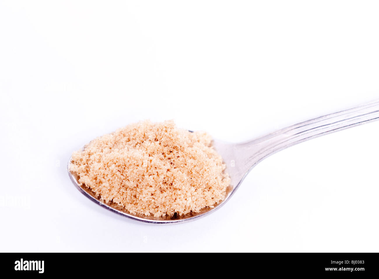 A spoonful of demerara cane sugar on a white background Stock Photo