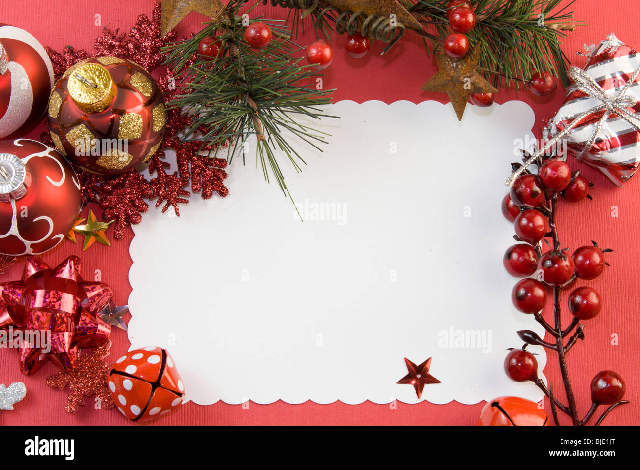 blank Christmas card with red elements including, baubles, bow, snowflake, berries, present, and copyspace Stock Photo