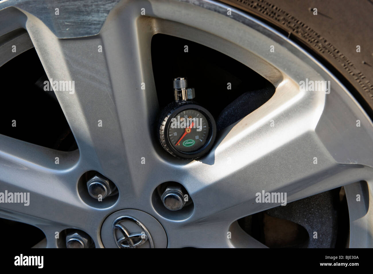 Round tire pressure gauge left on rim of Toyota close up closeup Stock Photo Alamy