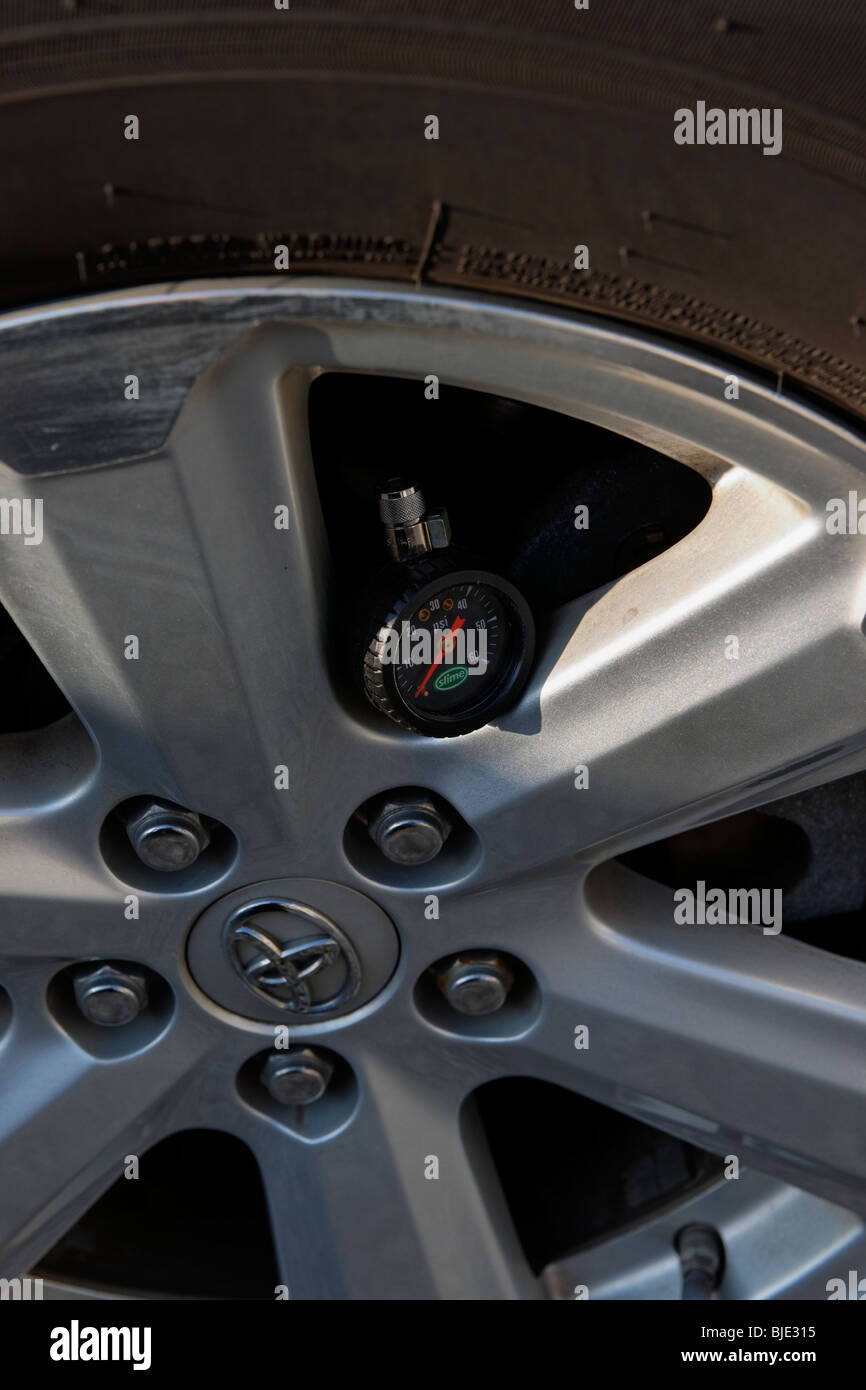 Round tire pressure gauge left on rim of Toyota car close up closeup Stock Photo Alamy