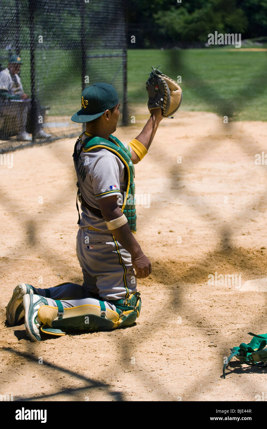 Baseball Catcher behind home plate. Shot from behind a chain link fence