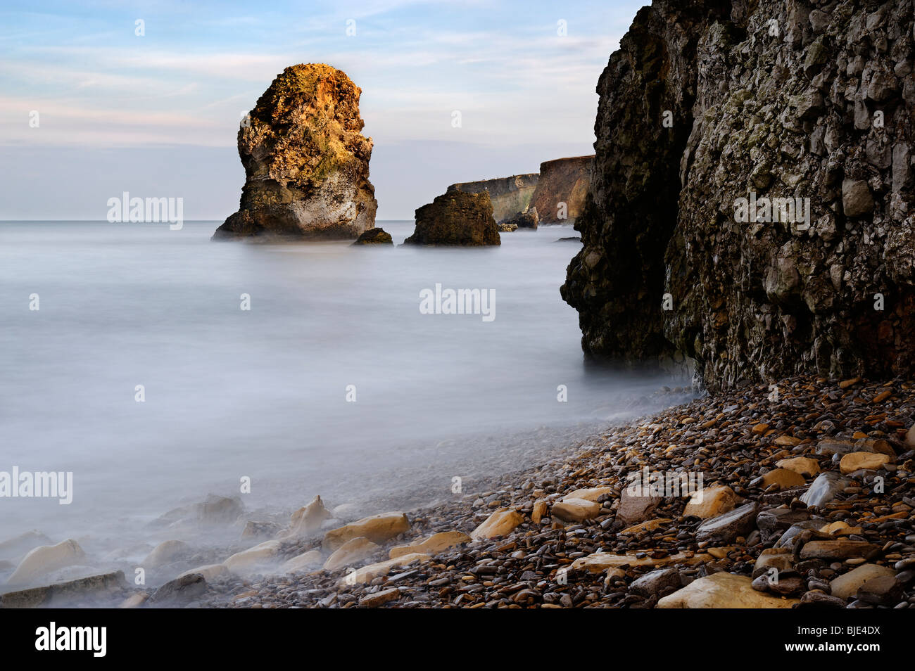 Evening light on cliffs and sea stacks in Marsden Bay near South Shields in Tyne and Wear. Stock Photo