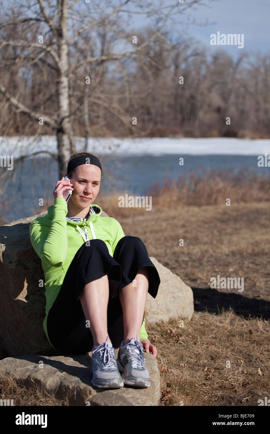 Young woman in casual clothing talking on smart phone outdoors Stock Photo