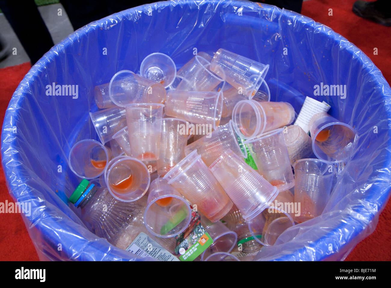 Blue recycling bin full of empty plastic cups to help save the environment Stock Photo