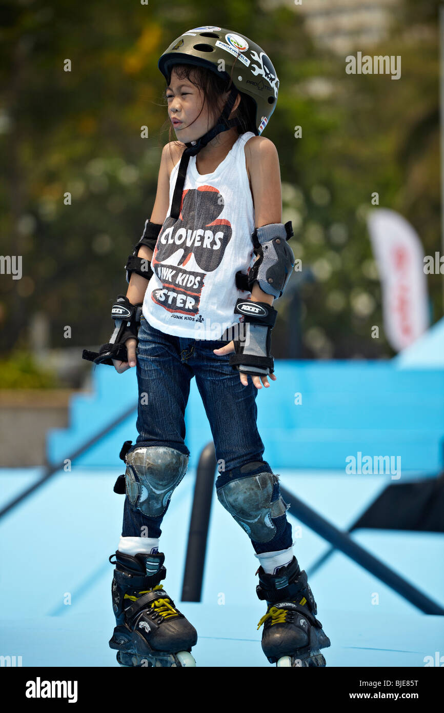 Young Asian child roller skating with full protective equipment