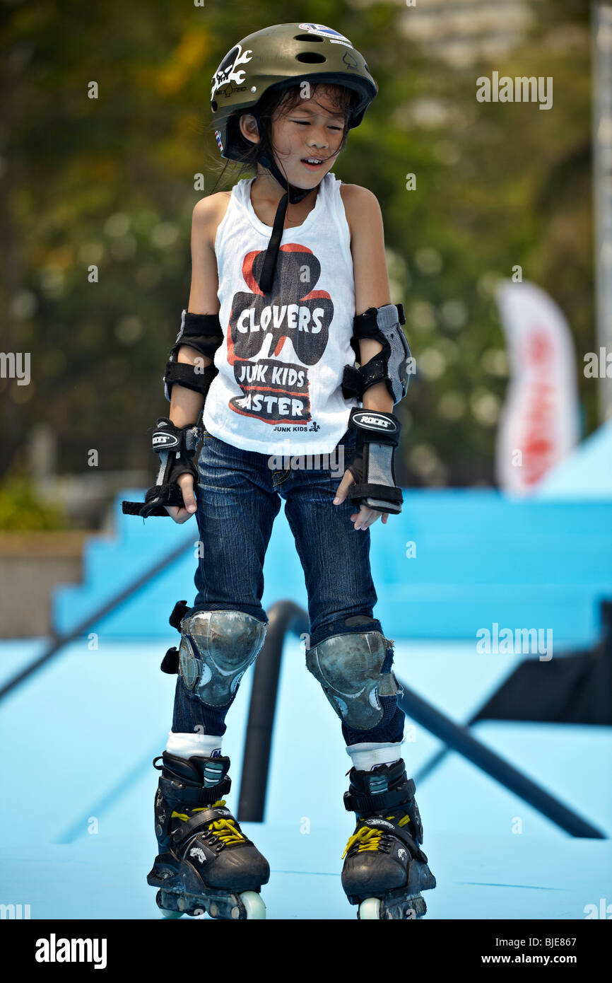 Young Asian child roller skating with full protective equipment