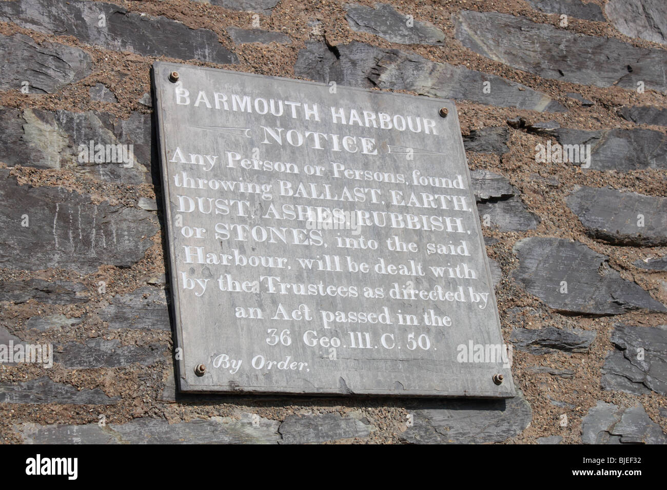 Inscribed slate sign on the wall of the Harbour Master's office in Barmouth Harbour prohibiting dumping into the harbour Stock Photo