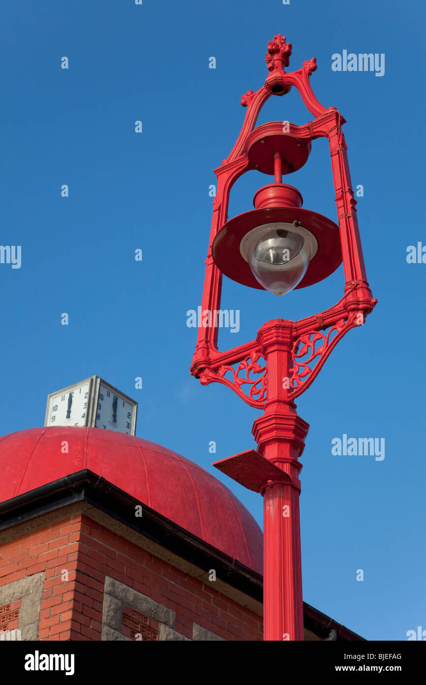 Old iron lamppost, red against blue sky Stock Photo