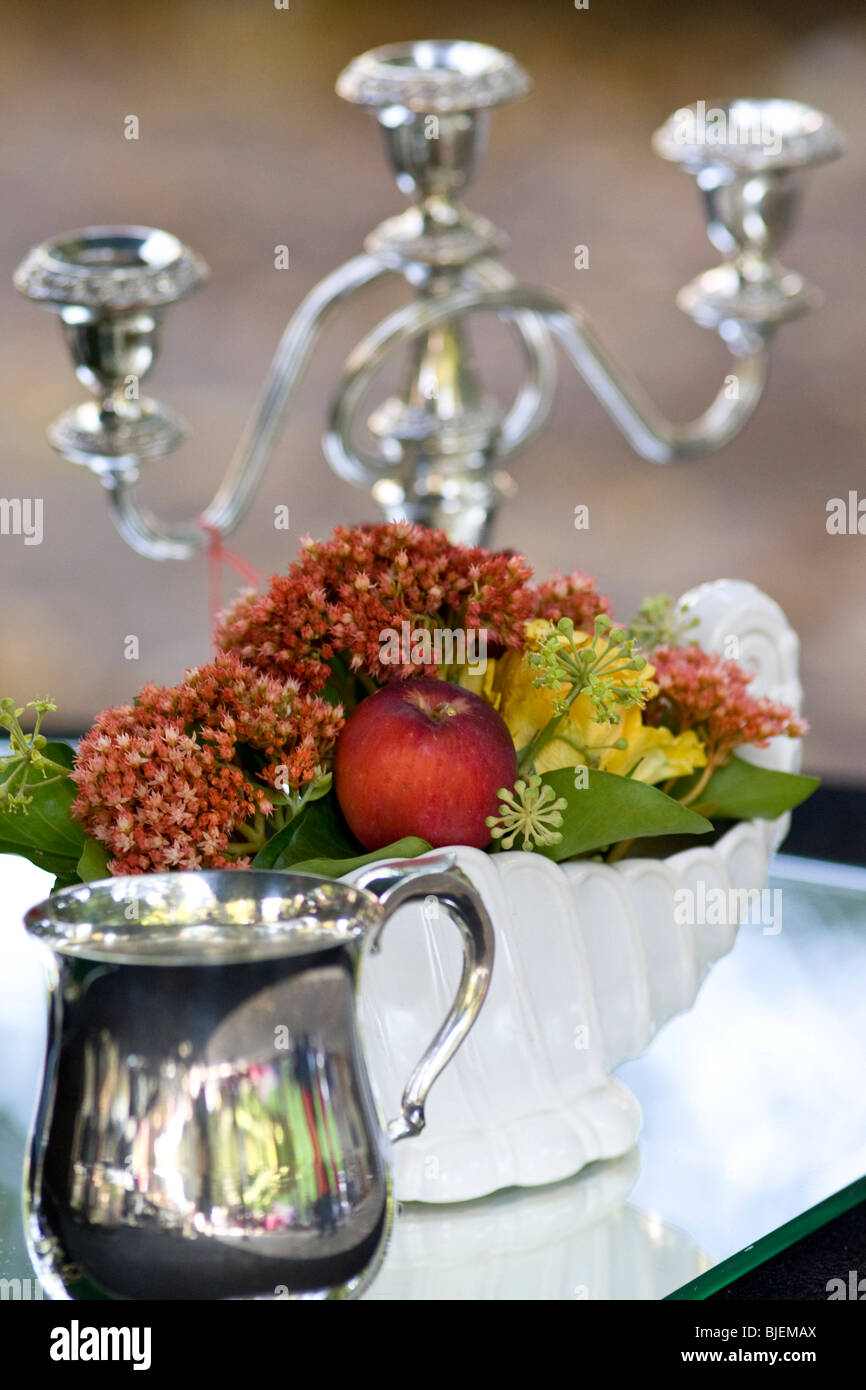 Candleholder, flower vase and cannikin on a glass table, close-up Stock Photo