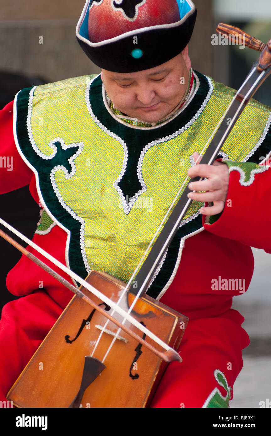 Mongolian man playing traditional 'morin khur' music with horse-head fiddle. Stock Photo