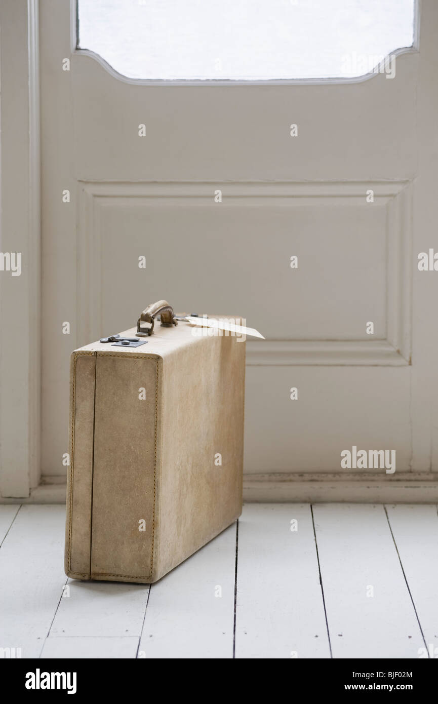 Old fashioned suitcase with luggage tag at front door Stock Photo Alamy