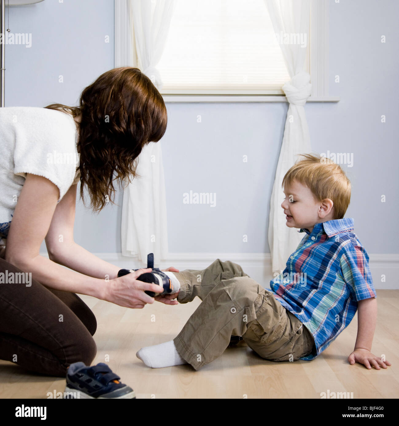 mother dressing her son Stock Photo Alamy