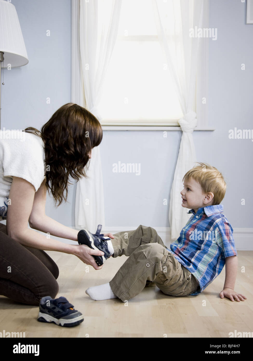 mother dressing her son Stock Photo Alamy