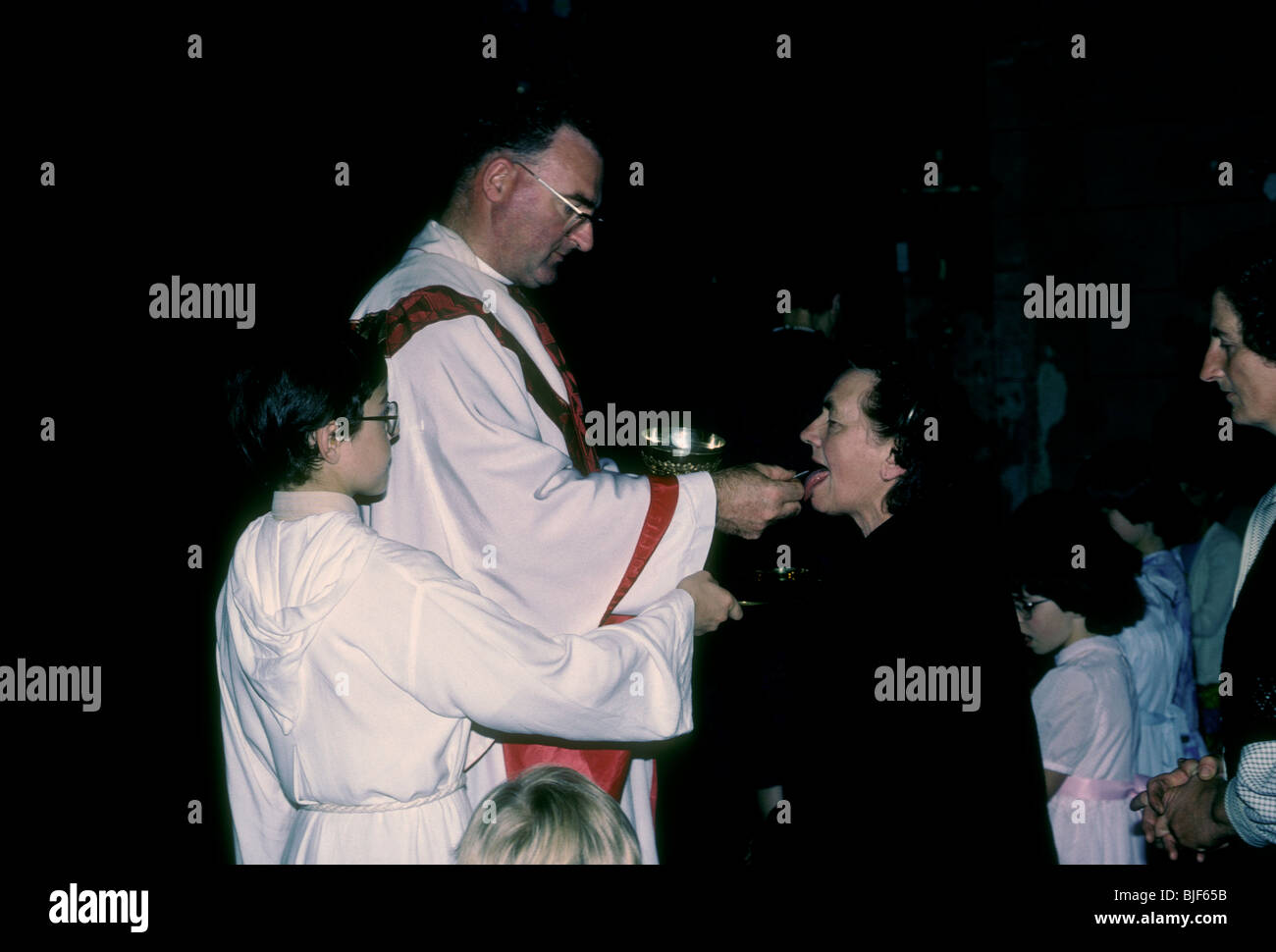 French Basque priest giving communion sacrament Roman Catholic Mass in the French Basque Country in the town of Macaye France Stock Photo