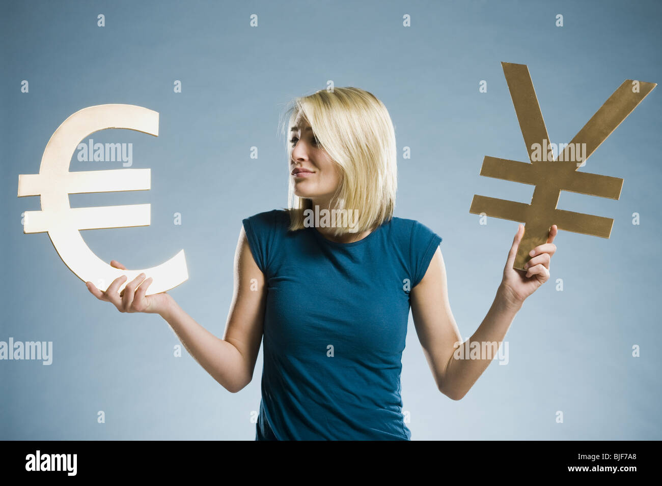 woman holding up currency symbols Stock Photo