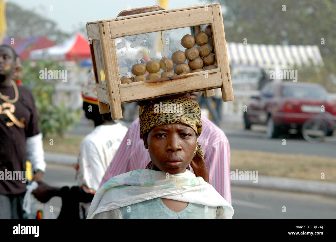 A young woman sells food to football supporters outside the football stadium in Accra. Ghana, West Africa, Africa Stock Photo