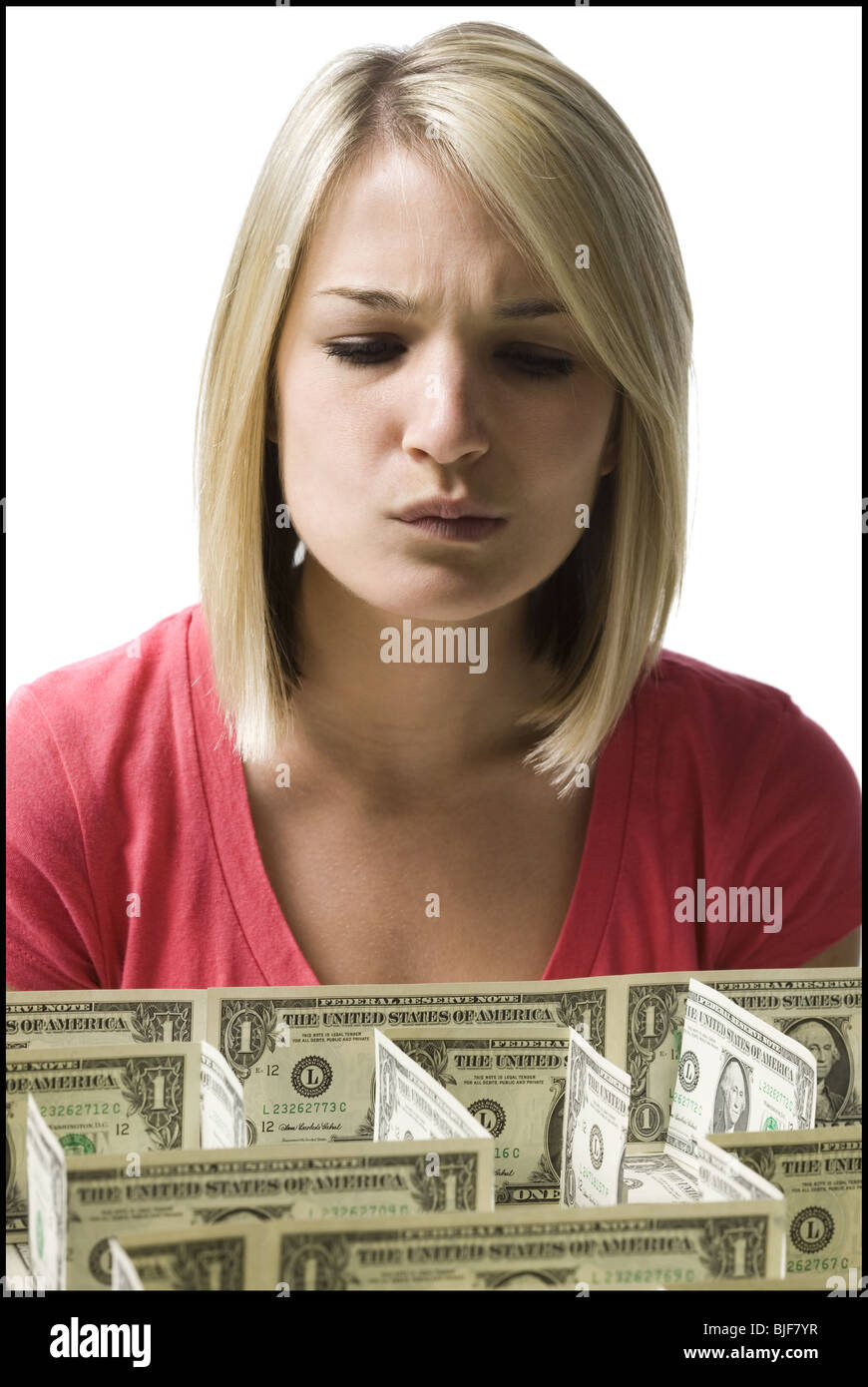 woman looking at a maze made of dollars Stock Photo