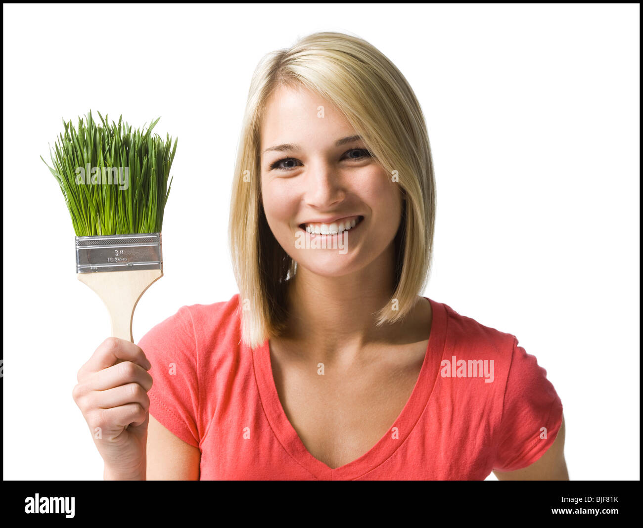 woman with a paint brush made of grass Stock Photo