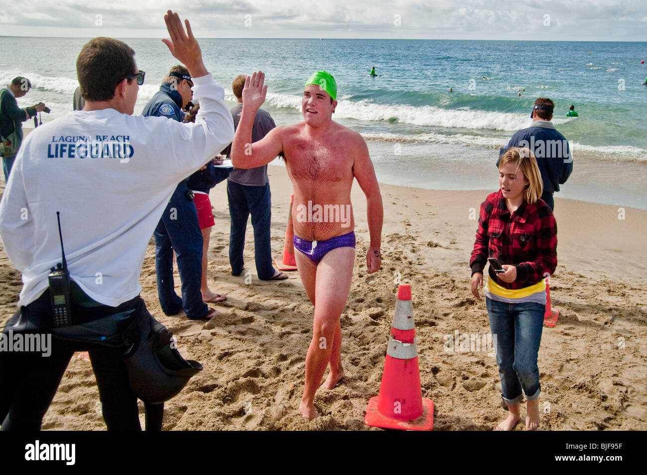 Lifeguard contestant in Laguna Beach, California, comes ashore after a long-distance qualifying swim in cold 53-degree water Stock Photo