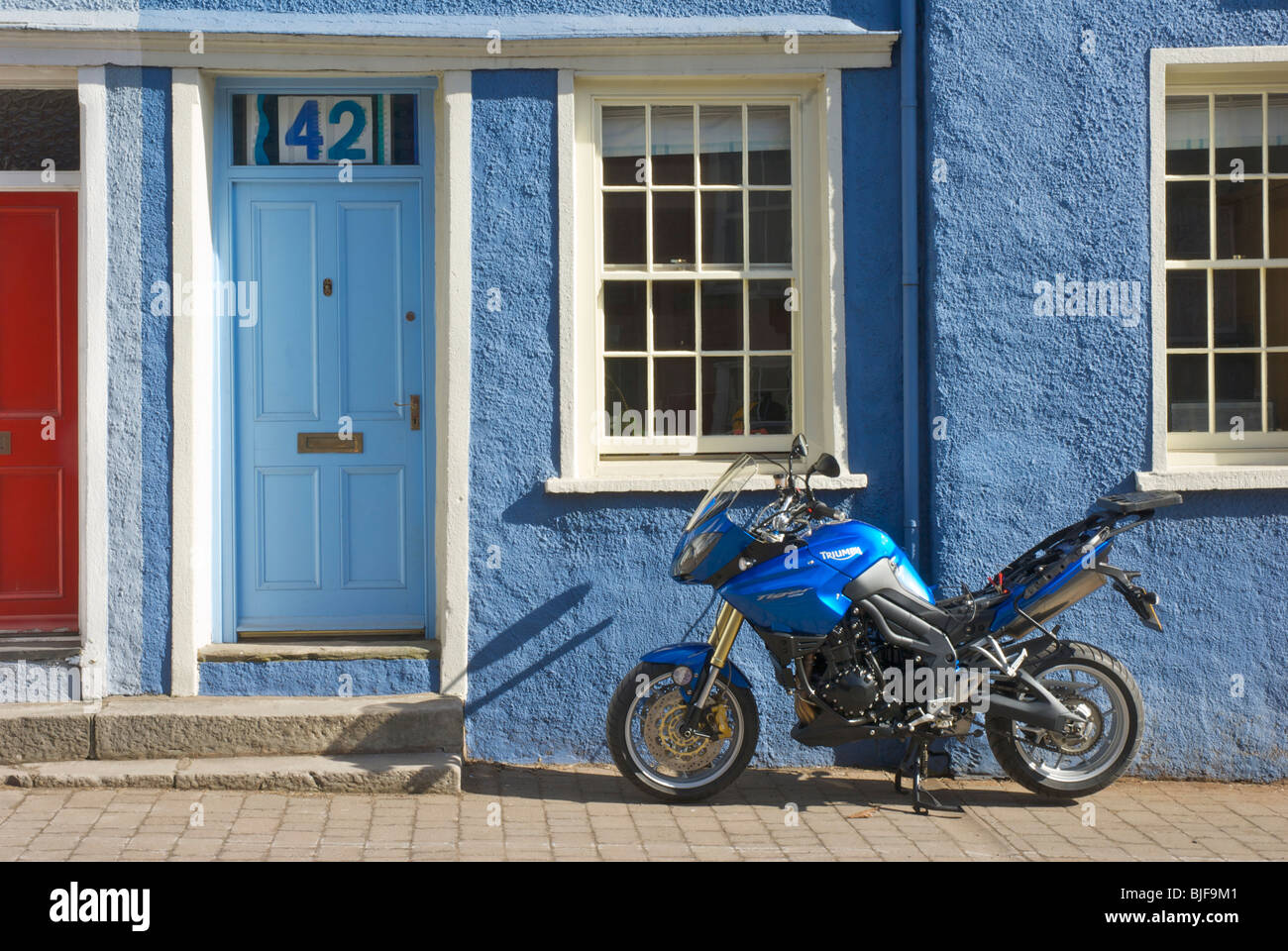 Motorbike parked (and getting its battery charged) on Soutergate, Ulverston, Cumbria, England UK Stock Photo