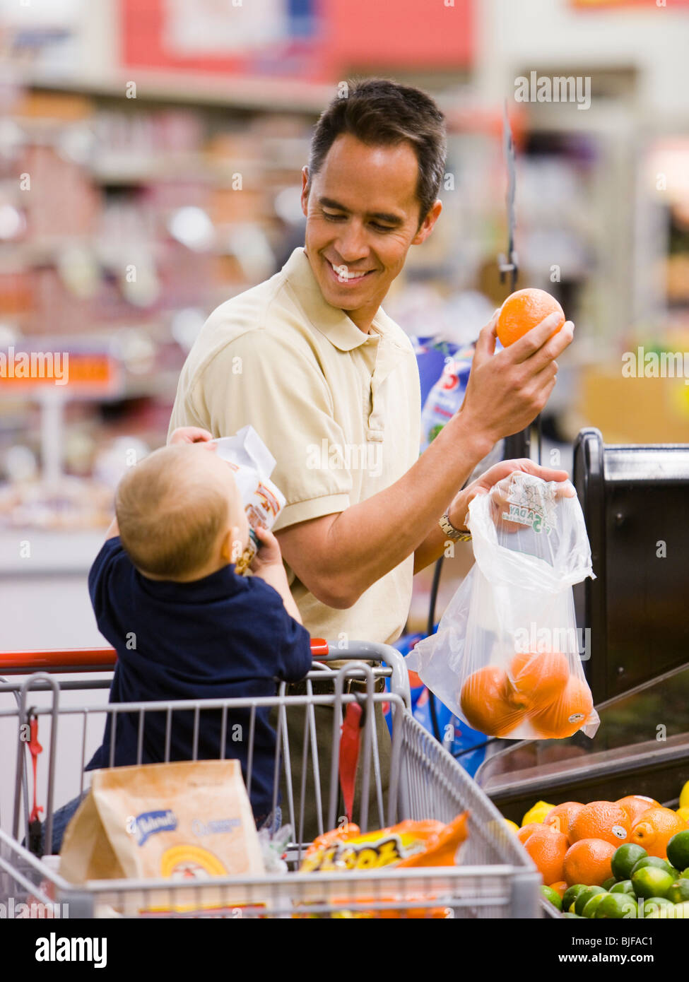 man grocery shopping with baby Stock Photo Alamy