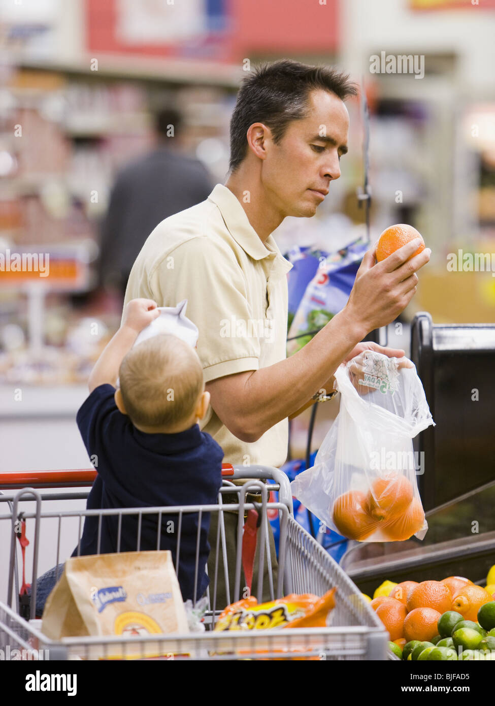 man grocery shopping with baby Stock Photo Alamy