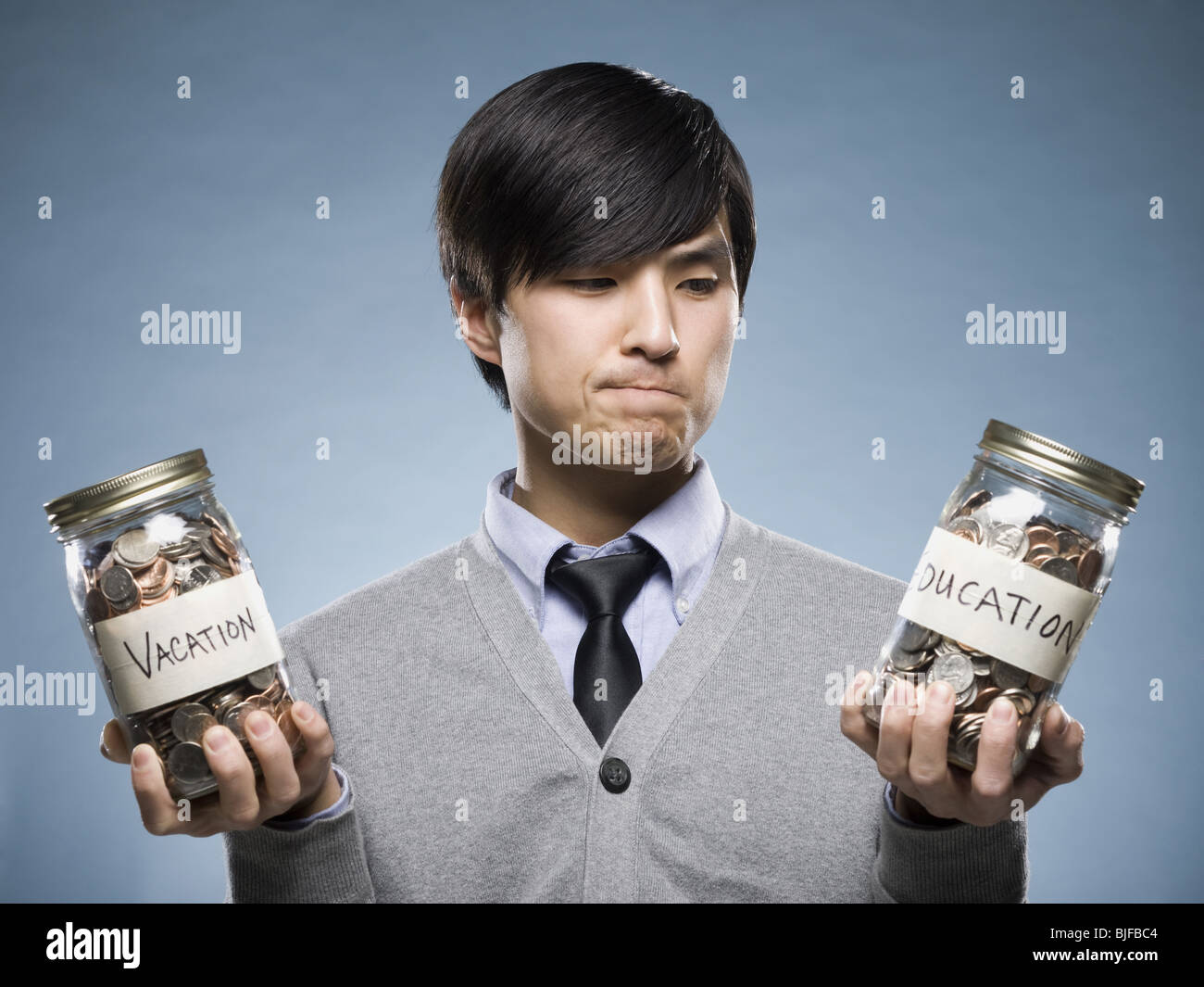 man holding two jars of coins Stock Photo