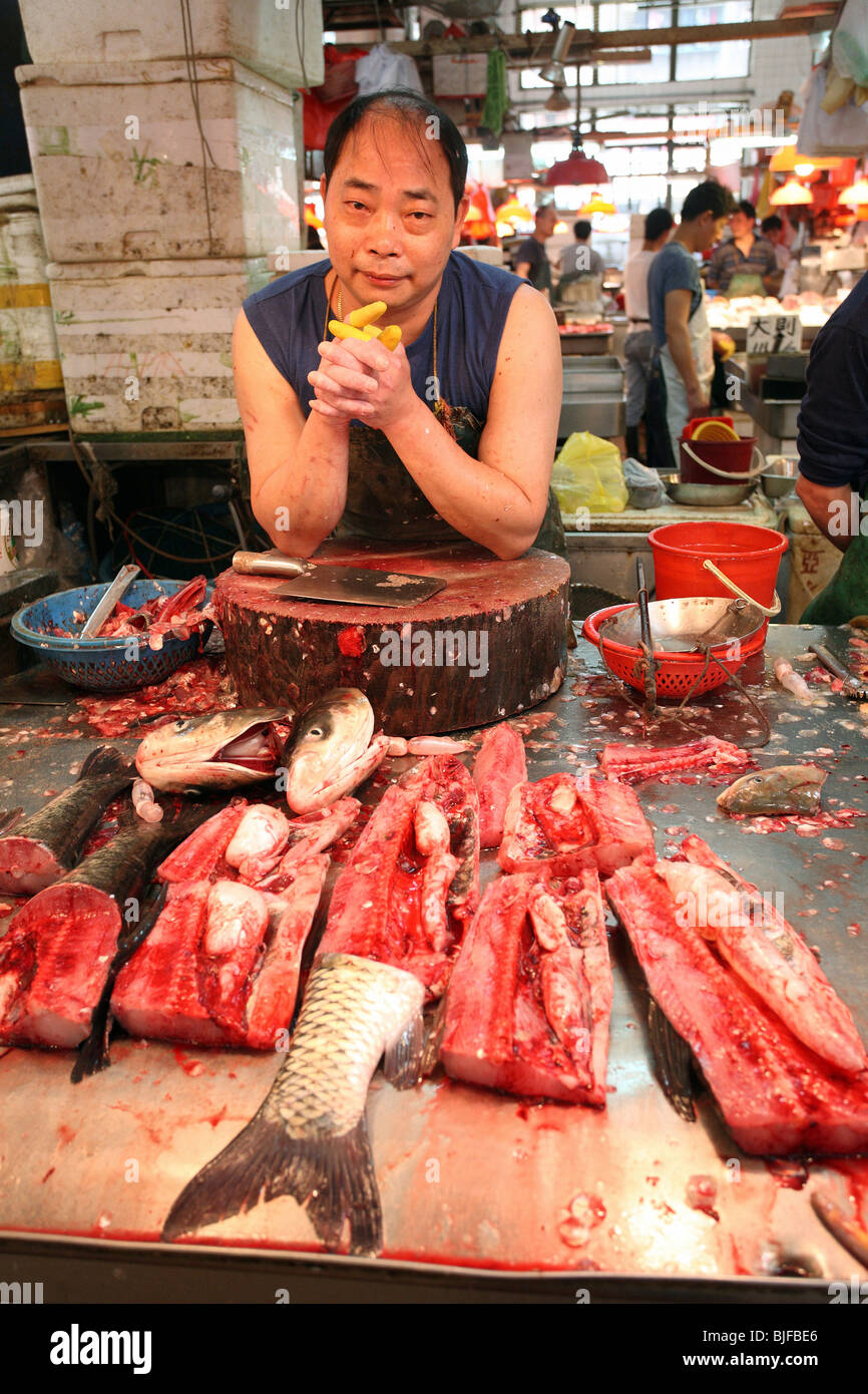 Fish seller waiting for customers, Macao, China Stock Photo