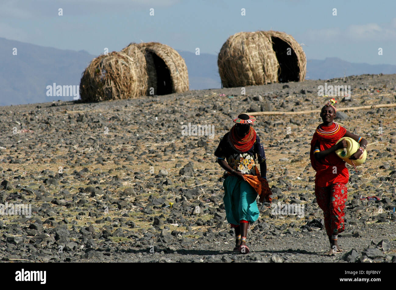 Women from the Traditional El-Molo tribe walk down to the waters edge of Lake Turkana. Northern Kenya, Kenya, Africa Stock Photo