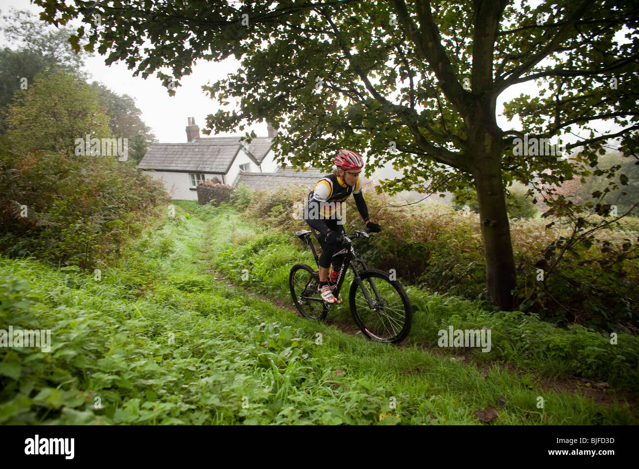 British mountain biker Liam Killeen rides a village trail Stock Photo