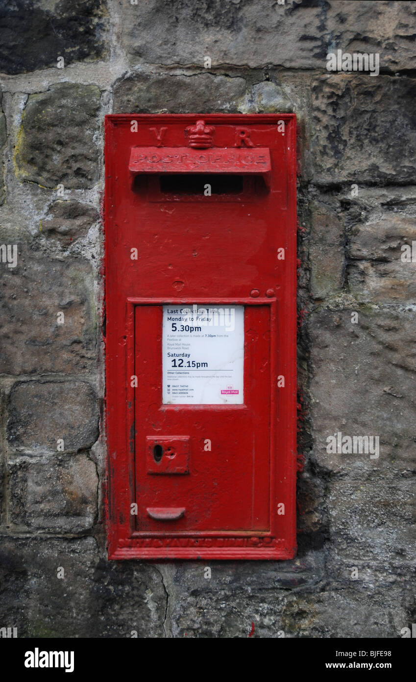 Red Victorian post box set in a wall. Stock Photo