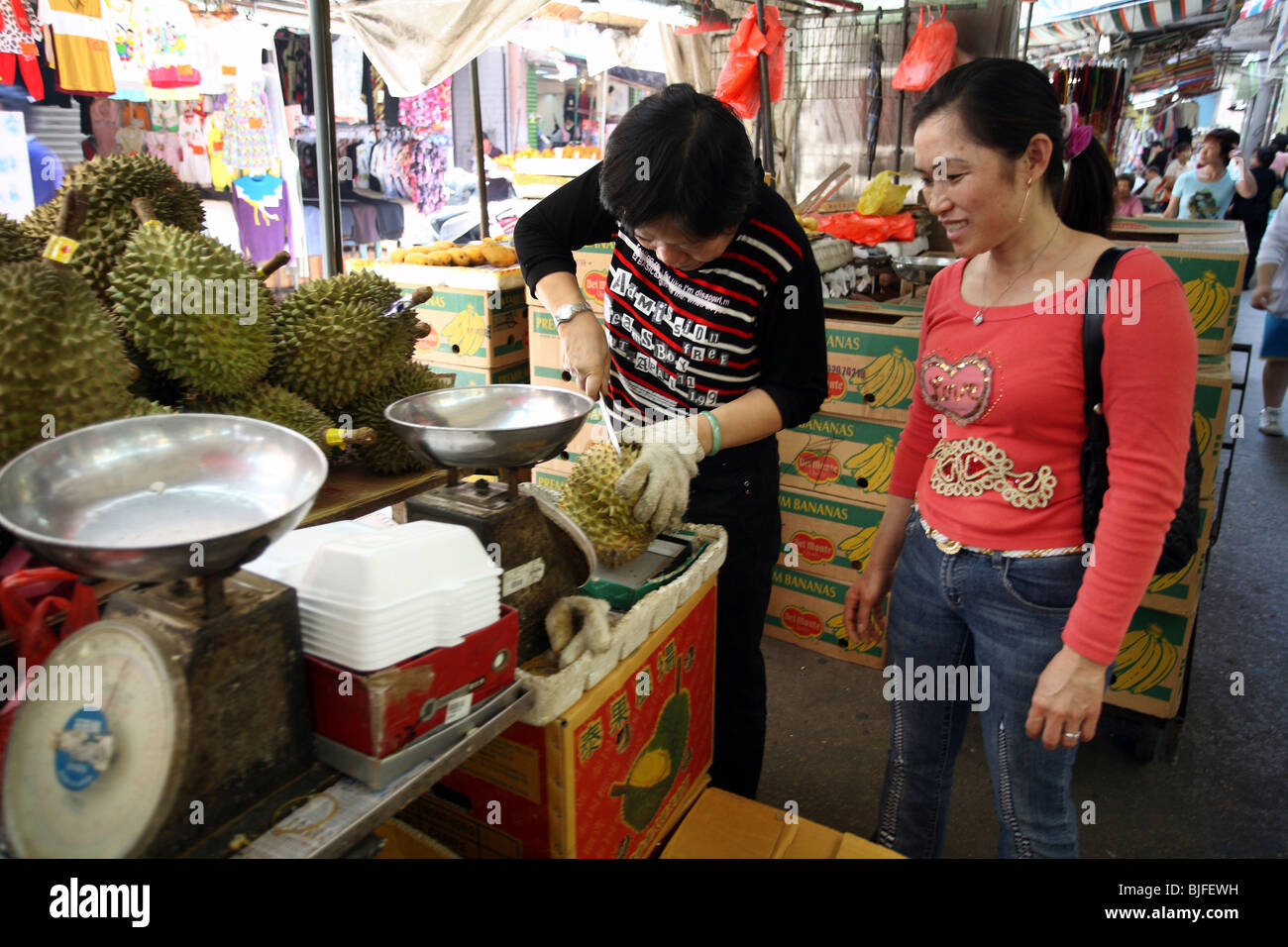 Woman checks a dorian fruit, Macao, China Stock Photo