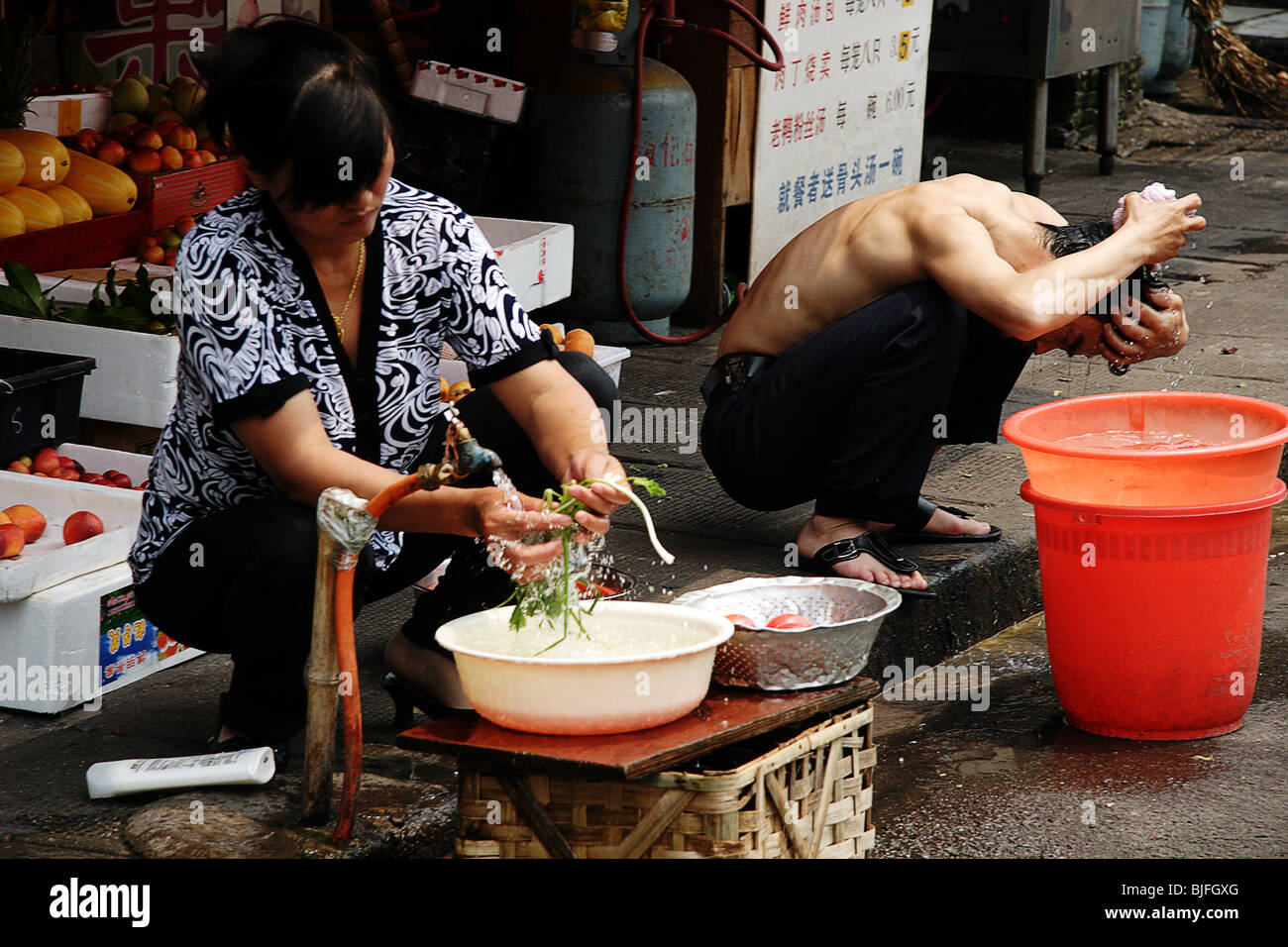 Woman washing vegetables at store in Shanghai, China Stock Photo