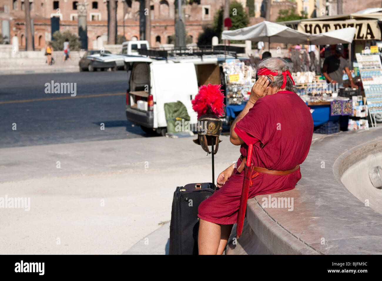 Man dressed as Roman Gladiator in the street of Rome speaking at his mobile phone. Rome, Italy Stock Photo