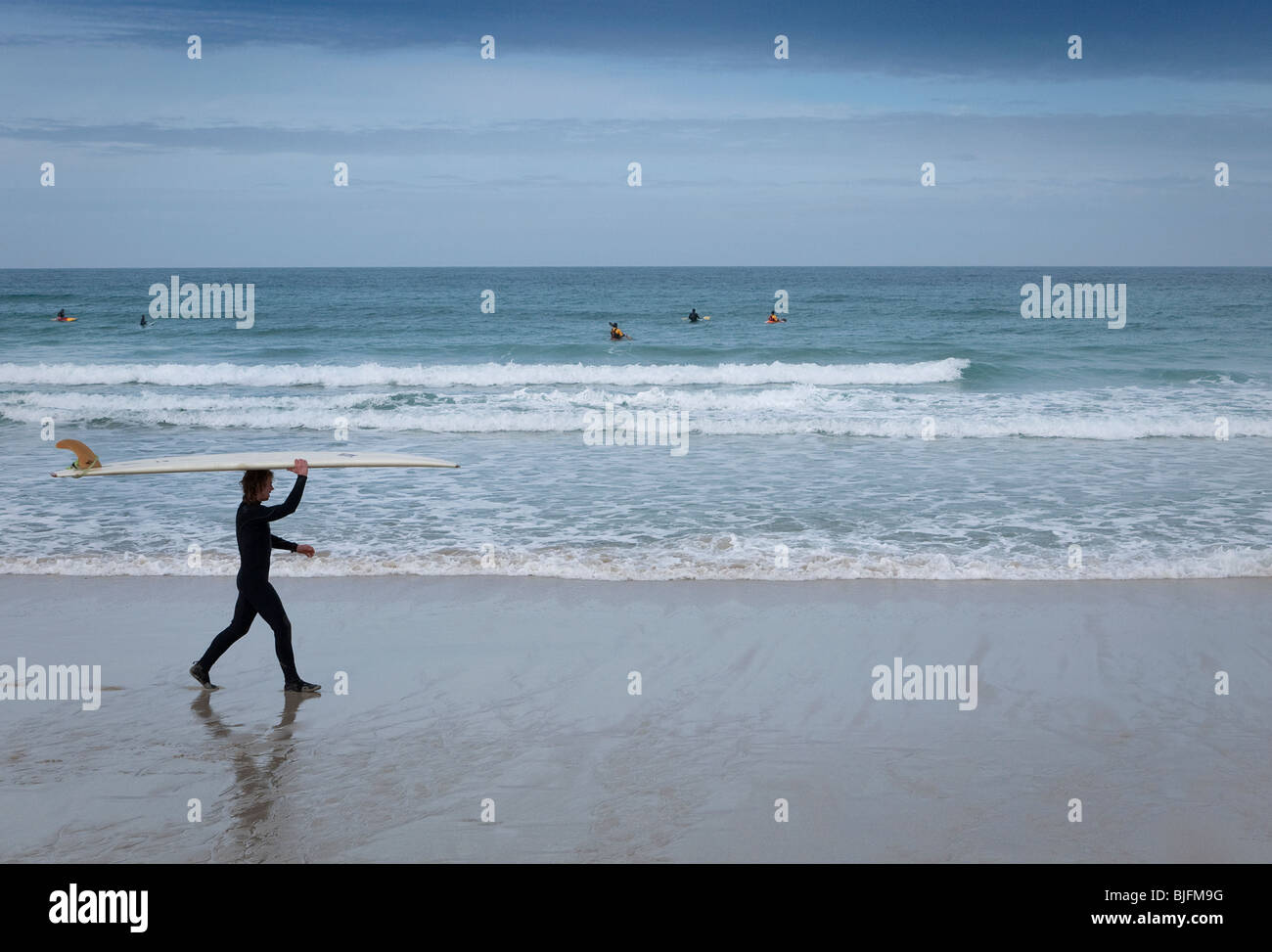Surfer on the beach at Sennen Cove Cornwall England Stock Photo