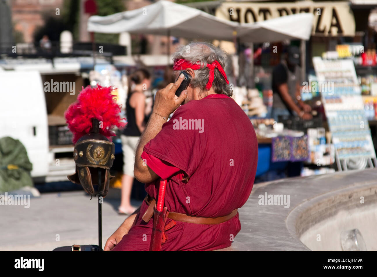 Man dressed as Roman Gladiator in the street of Rome speaking at his mobile phone. Rome, Italy Stock Photo