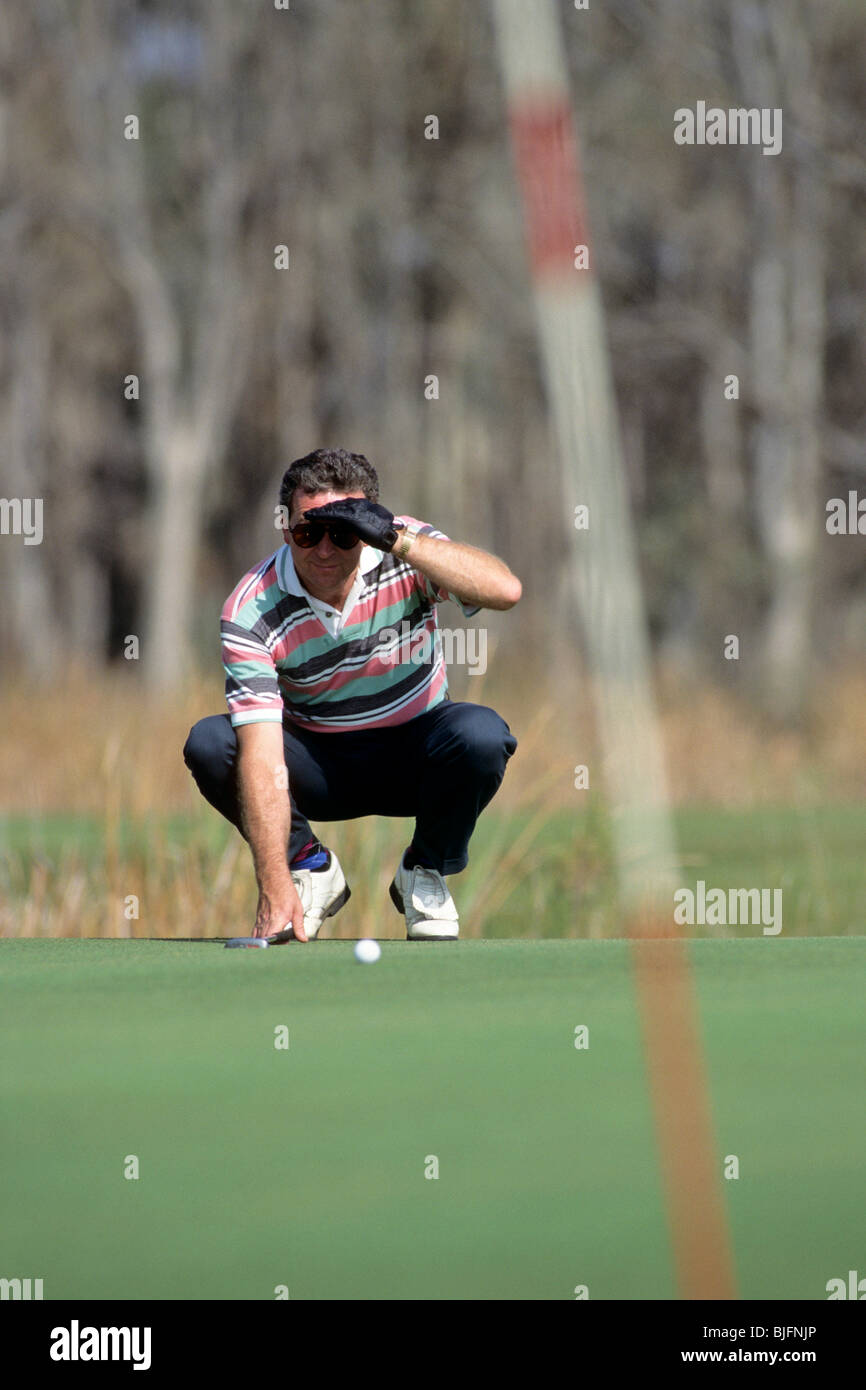 Golfer analyses his putt Stock Photo