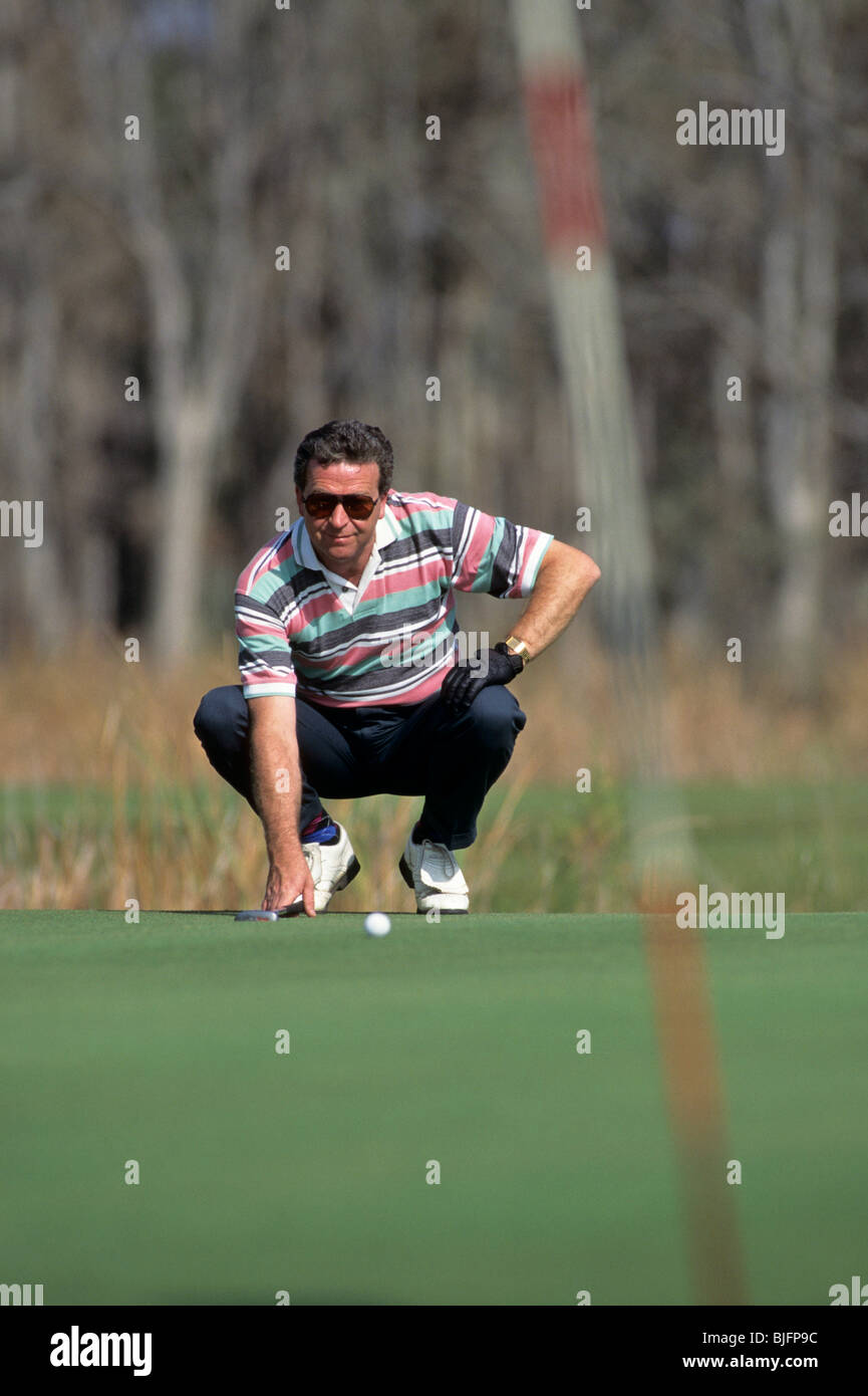 Golfer analyses his putt Stock Photo