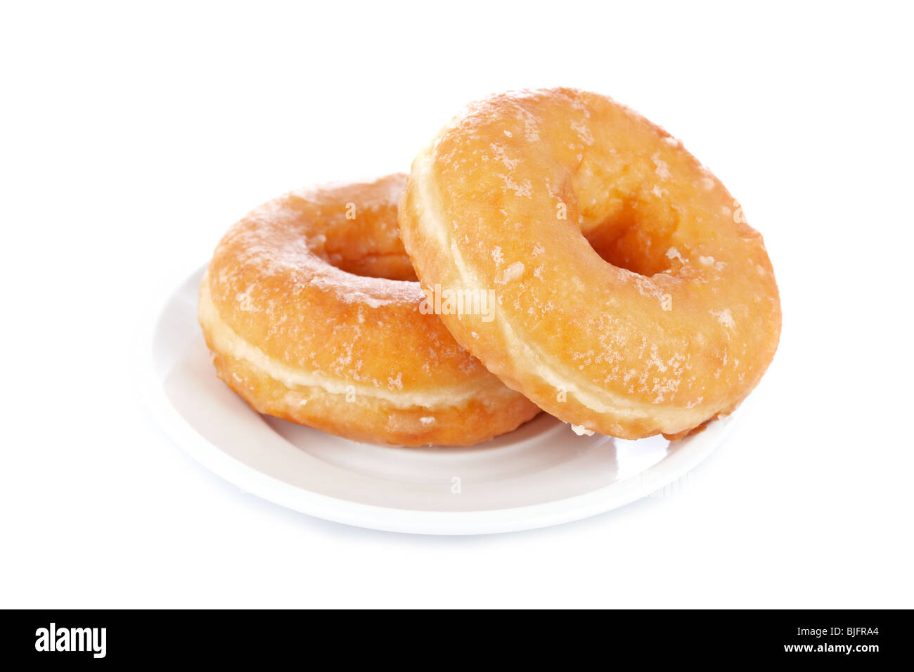 Two delicious donuts on a dish reflected on white background with shallow depth of field Stock Photo