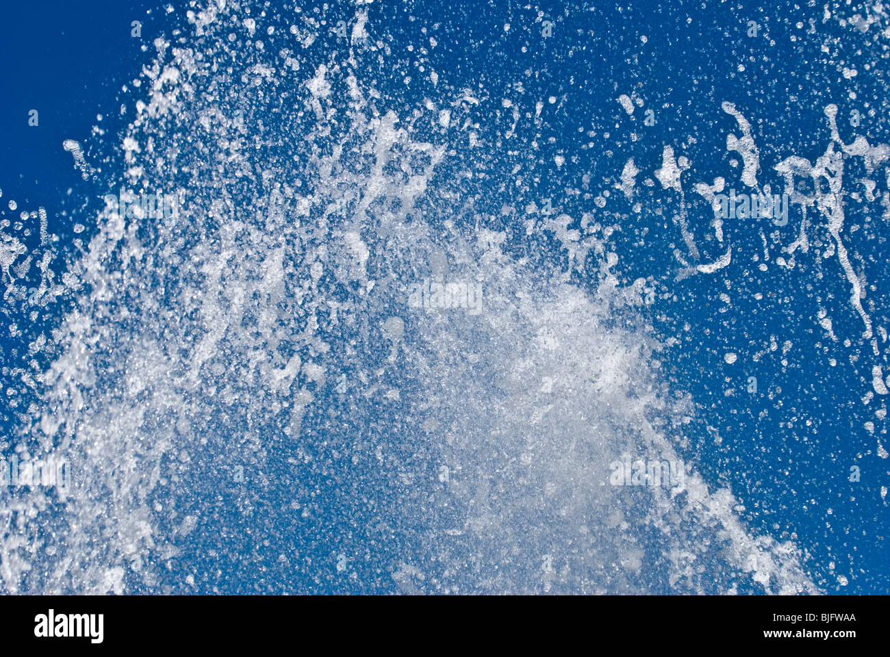 Water from fountain captured against blue sky Stock Photo