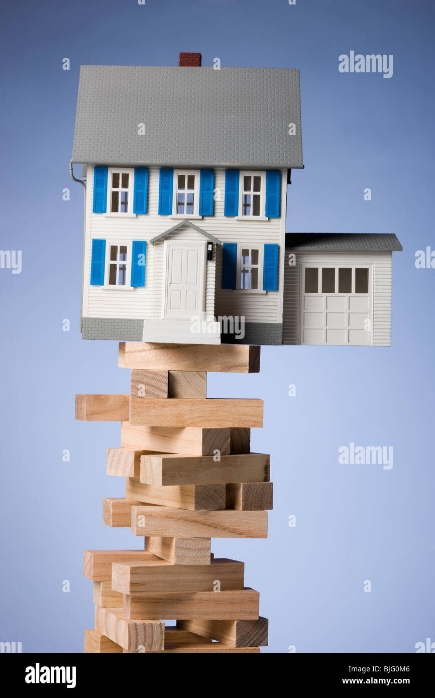 house perched precariously on a tower of blocks Stock Photo