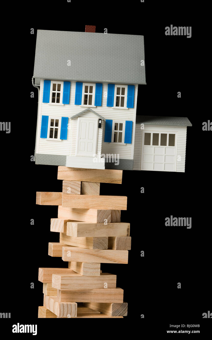 house perched precariously on a tower of blocks Stock Photo